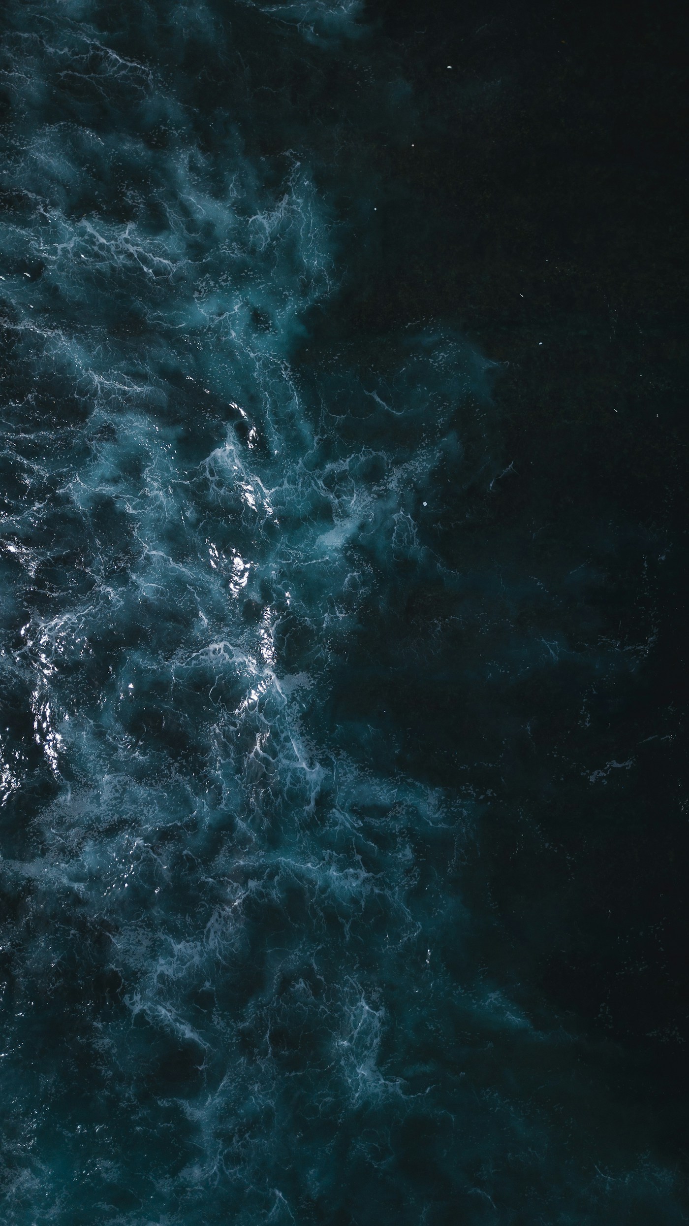 Olas y espuma sobre el azul profundo del océano